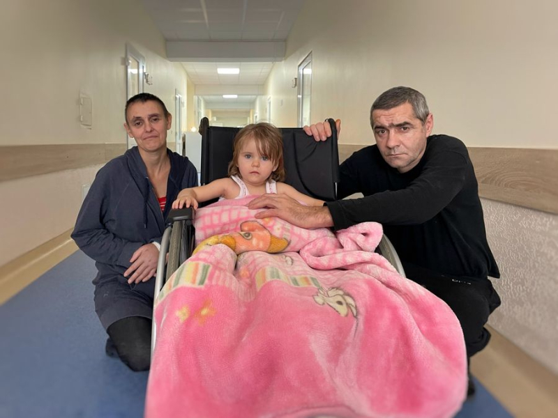 El padre quiere poner de pie a su hija Lisa de 2 años, que no puede caminar porque de los rusos 